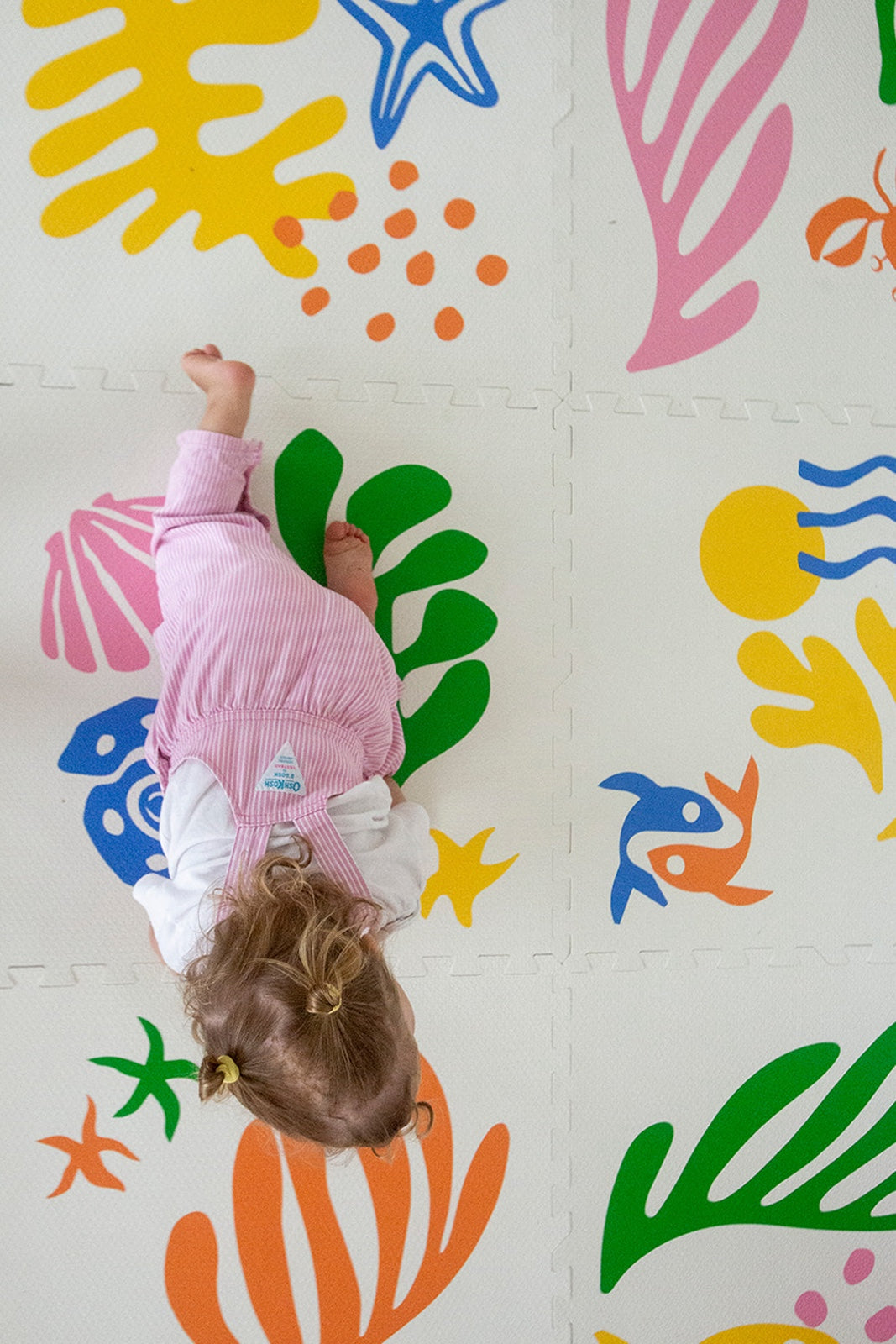 baby crawling on bright, colourful foam play mat